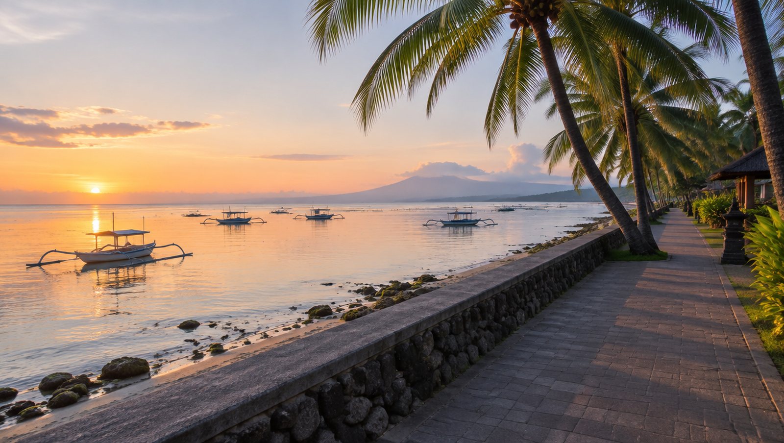 A beachfront promenade at dawn with a low seawall